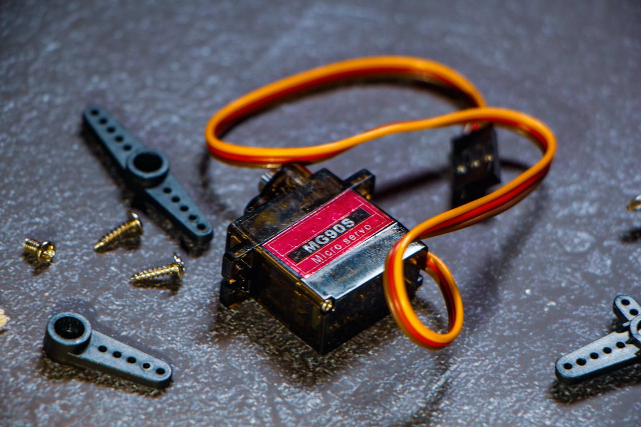 Close-up of MG996R micro servo motor with accessories on textured surface.